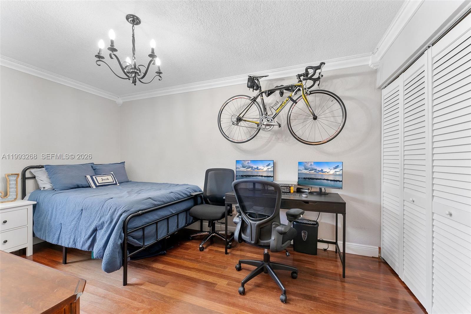 11798 Southwest 32nd Street Miami, FL 33165 - Photo 27 of 31 a bedroom with a bed a desk and chair with wooden floor