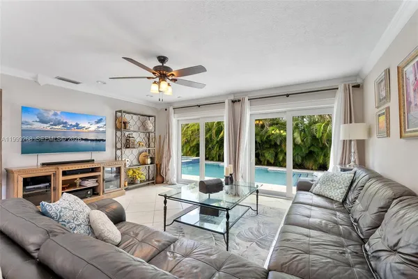 a living room with furniture a large window and a flat screen tv