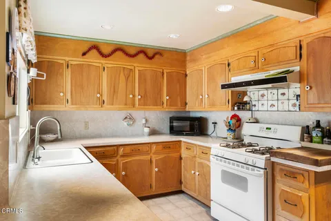 a kitchen with stainless steel appliances granite countertop a sink and a stove next to a window
