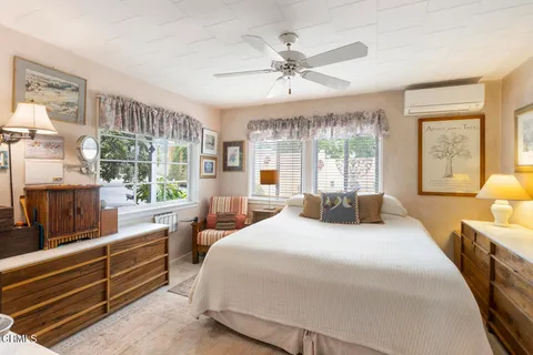 a bedroom with a large bed and windows