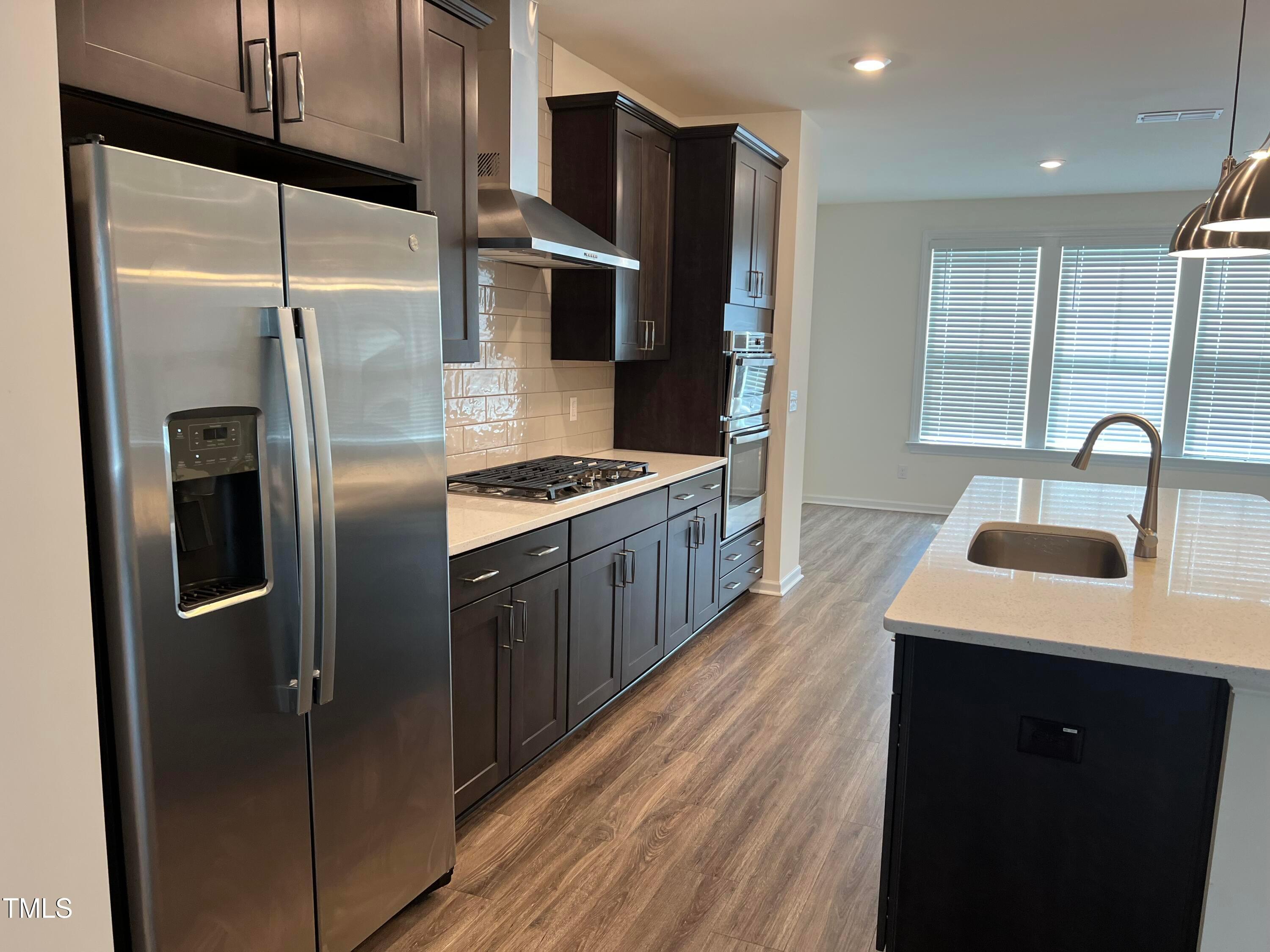 6932 Leesville Road Raleigh, NC 27613 - Photo 12 of 51 a kitchen with stainless steel appliances kitchen island a refrigerator sink and stove