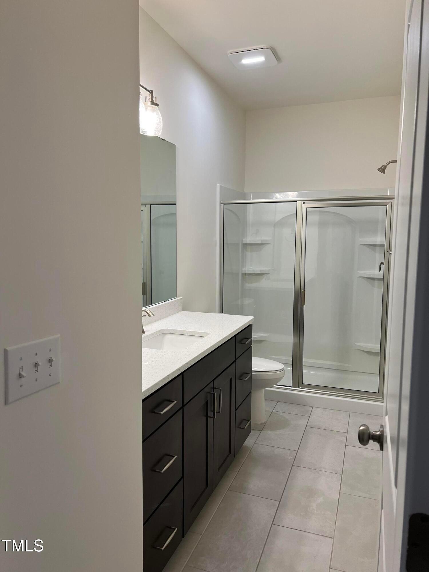 6932 Leesville Road Raleigh, NC 27613 - Photo 7 of 51 a bathroom with a granite countertop sink mirror and shower