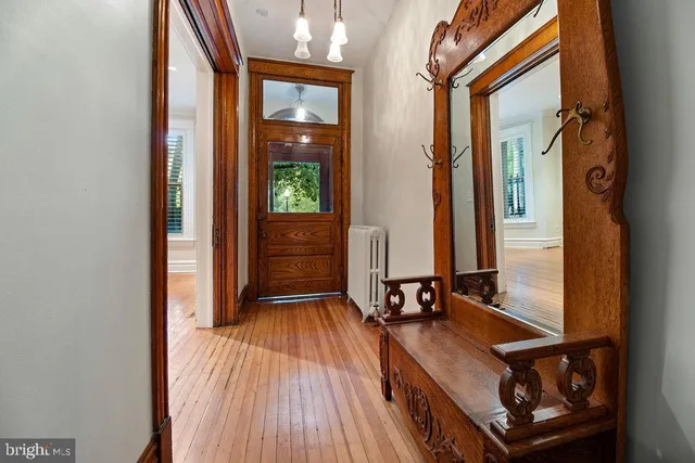 a view of an empty room with wooden floor fireplace and a window