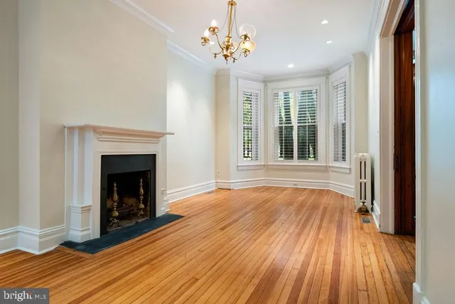 a view of a room with wooden floor a ceiling fan and window