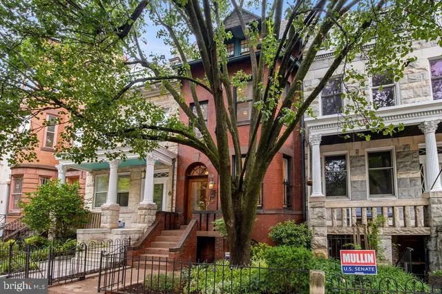 a front view of a house with a tree