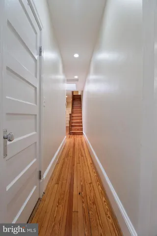 an empty room with wooden floor fireplace and windows