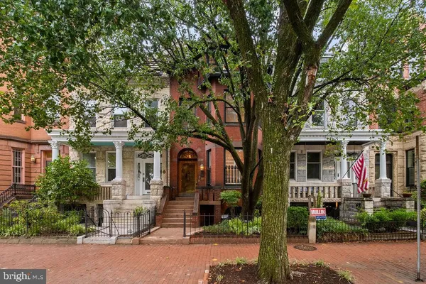 a front view of a house with a tree