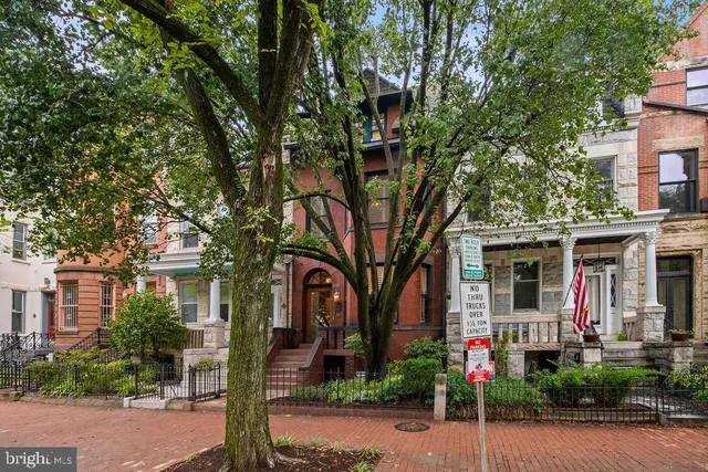 a front view of a house with a tree