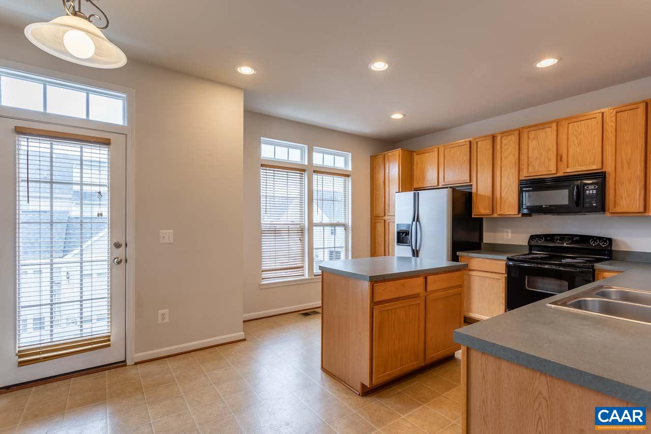 325 Rolkin Road Charlottesville, VA 22911 - Photo 12 of 32 a kitchen with stainless steel appliances granite countertop a stove a sink dishwasher a refrigerator and a microwave oven with wooden floor