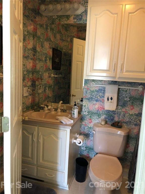 22382 Oakwood Road Albemarle, NC 28001 - Photo 11 of 21 a bathroom with a granite countertop toilet sink and mirror