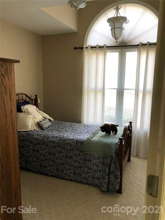 22382 Oakwood Road Albemarle, NC 28001 - Photo 13 of 21 a bedroom with a bed and a chandelier