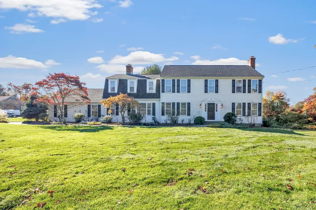 a front view of a house with yard and swimming pool