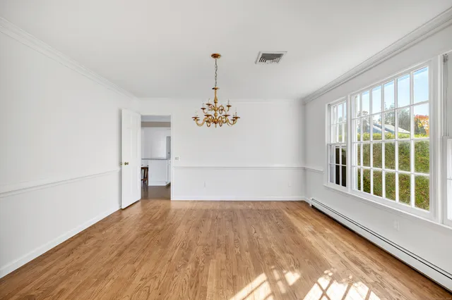a view of a room with wooden floor and windows