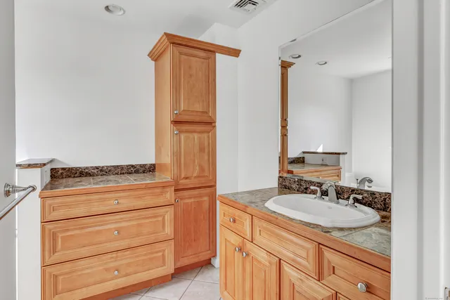 a bathroom with a granite countertop sink and a mirror