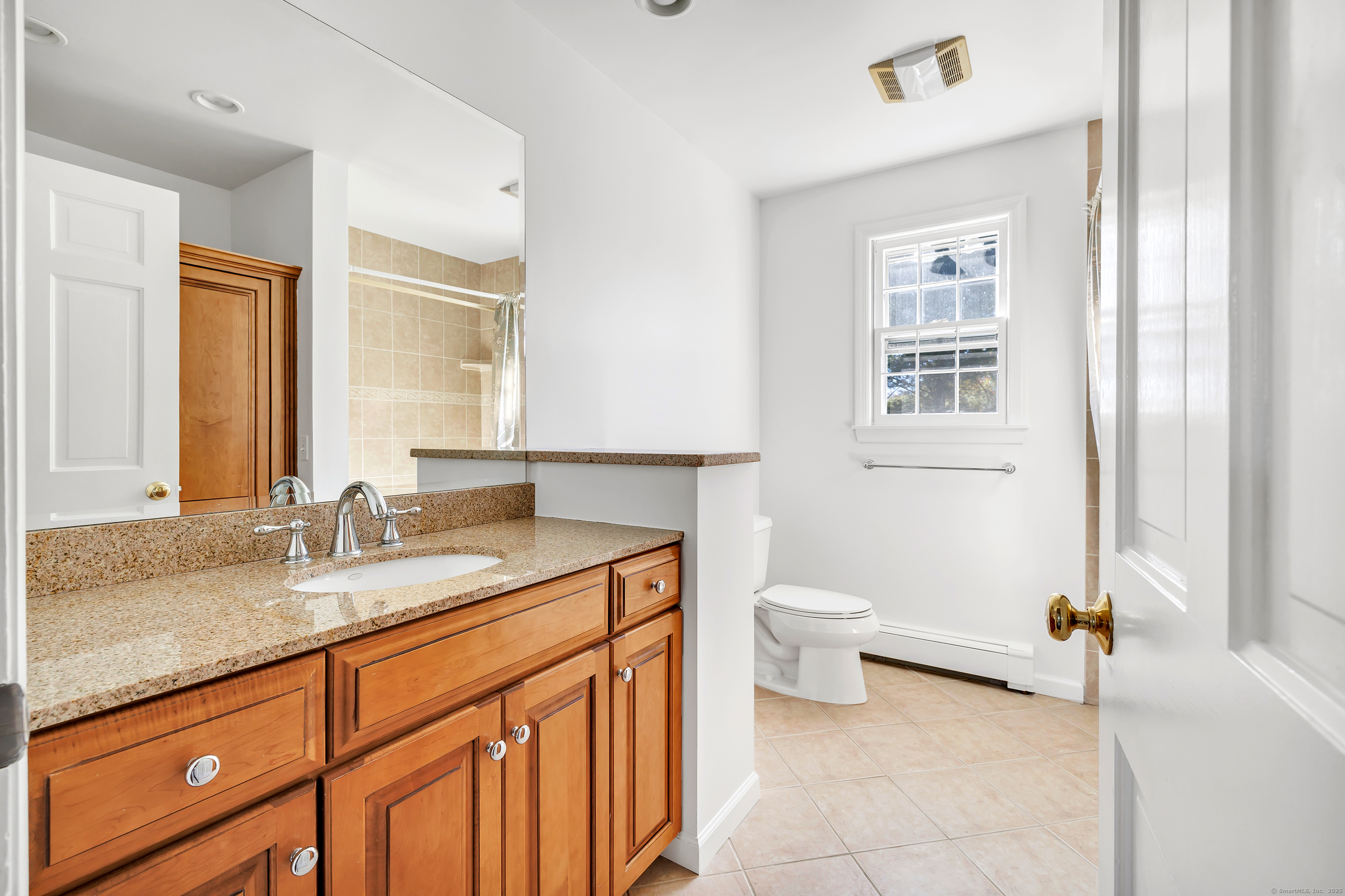 41 Butternut Lane Fairfield, CT 06890 - Photo 24 of 33 a bathroom with a granite countertop sink a toilet and a mirror