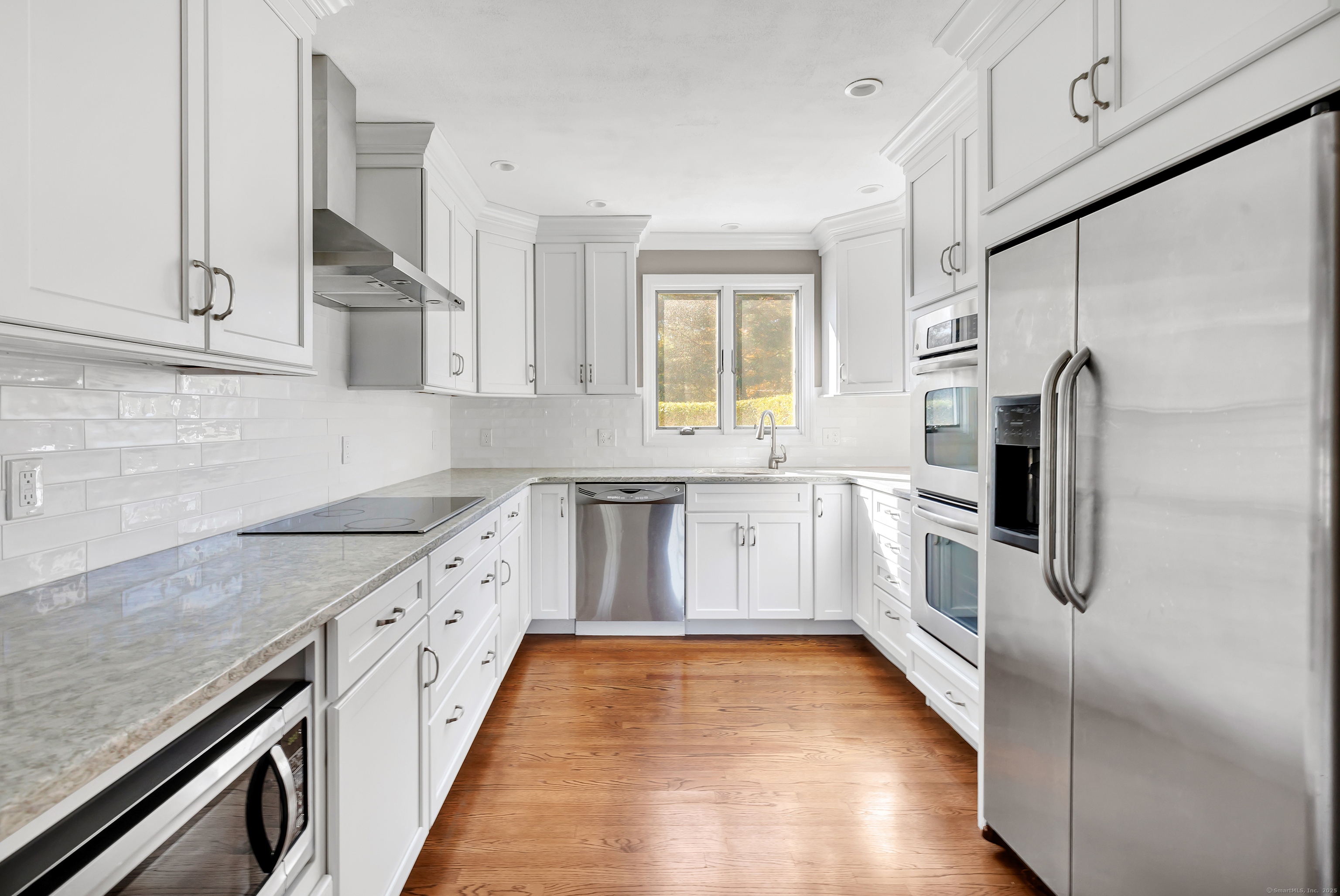 41 Butternut Lane Fairfield, CT 06890 - Photo 8 of 33 a white kitchen with granite countertop a sink a counter top space stainless steel appliances and cabinets