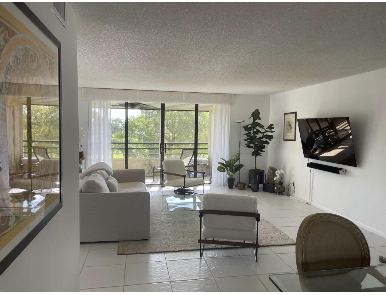 7170 Promenade Drive, Unit 301 Boca Raton, FL 33433 - Photo 2 of 7 a living room with furniture and a flat screen tv