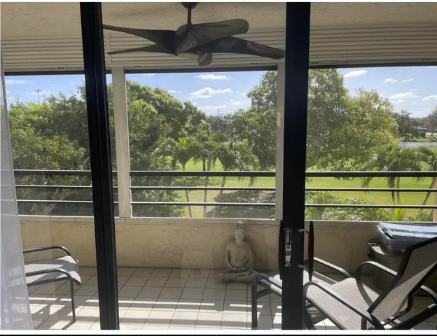 a view of a room with a large window and sitting space