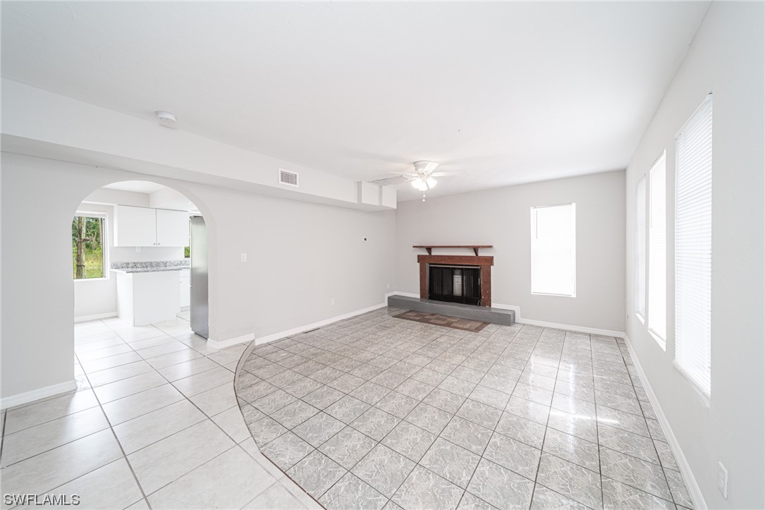 12451 Shawnee Road Fort Myers, FL 33913 - Photo 16 of 39 a view of empty room with wooden floor and fireplace