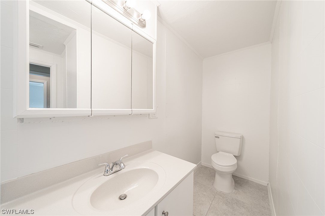 12451 Shawnee Road Fort Myers, FL 33913 - Photo 31 of 39 a bathroom with a toilet sink and mirror