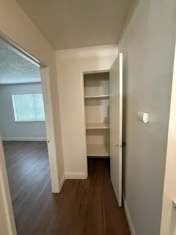 an empty room with wooden floor and entrance