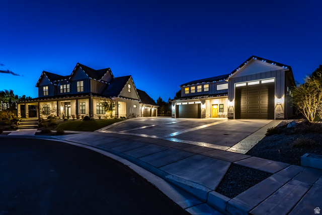 Modern farmhouse with board and batten siding, concrete driveway, stone siding, and a standing seam roof