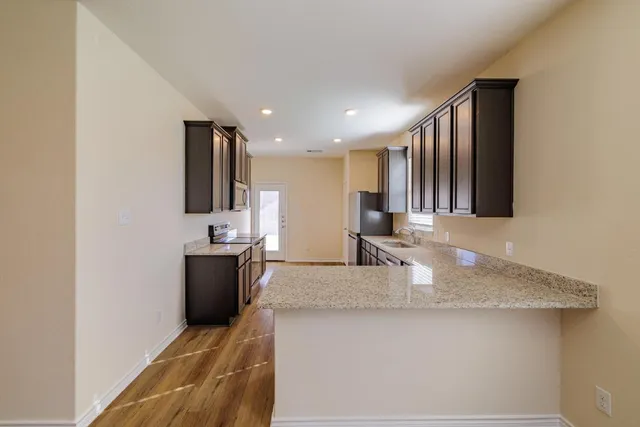 a kitchen with stainless steel appliances granite countertop a sink stove and refrigerator