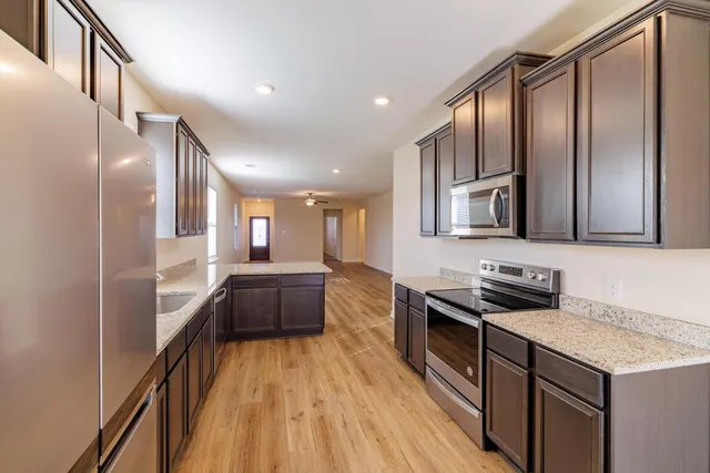 a kitchen with granite countertop a stove top oven and sink