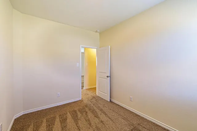 an empty room with closet and a ceiling fan