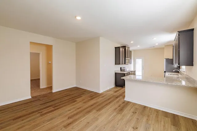 a view of a kitchen with wooden floor and a sink