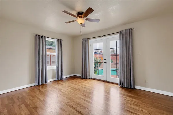 an empty room with wooden floor and windows