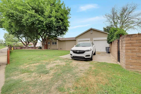 a view of a house with backyard and trees
