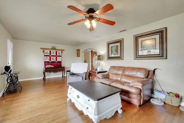 a living room with furniture and a wooden floor