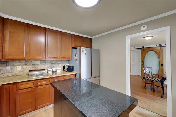 a kitchen with stainless steel appliances granite countertop a sink refrigerator and microwave
