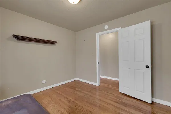 an empty room with wooden floor and closet