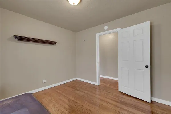 an empty room with wooden floor and closet
