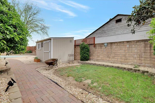 a backyard of a house with large tree and wooden fence