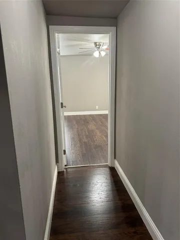 an empty room with wooden floor closet and windows