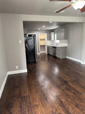a view of a living room a kitchen and a sink