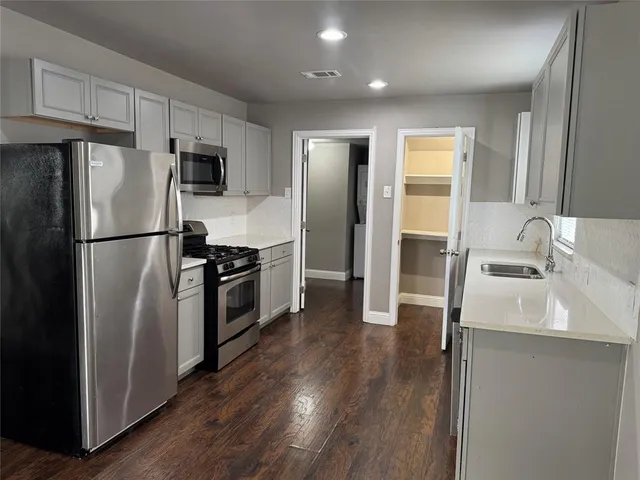 a kitchen with a refrigerator sink and wooden floor