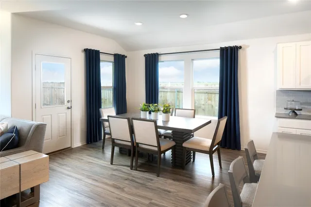 a kitchen with stainless steel appliances granite countertop a table chairs microwave and sink