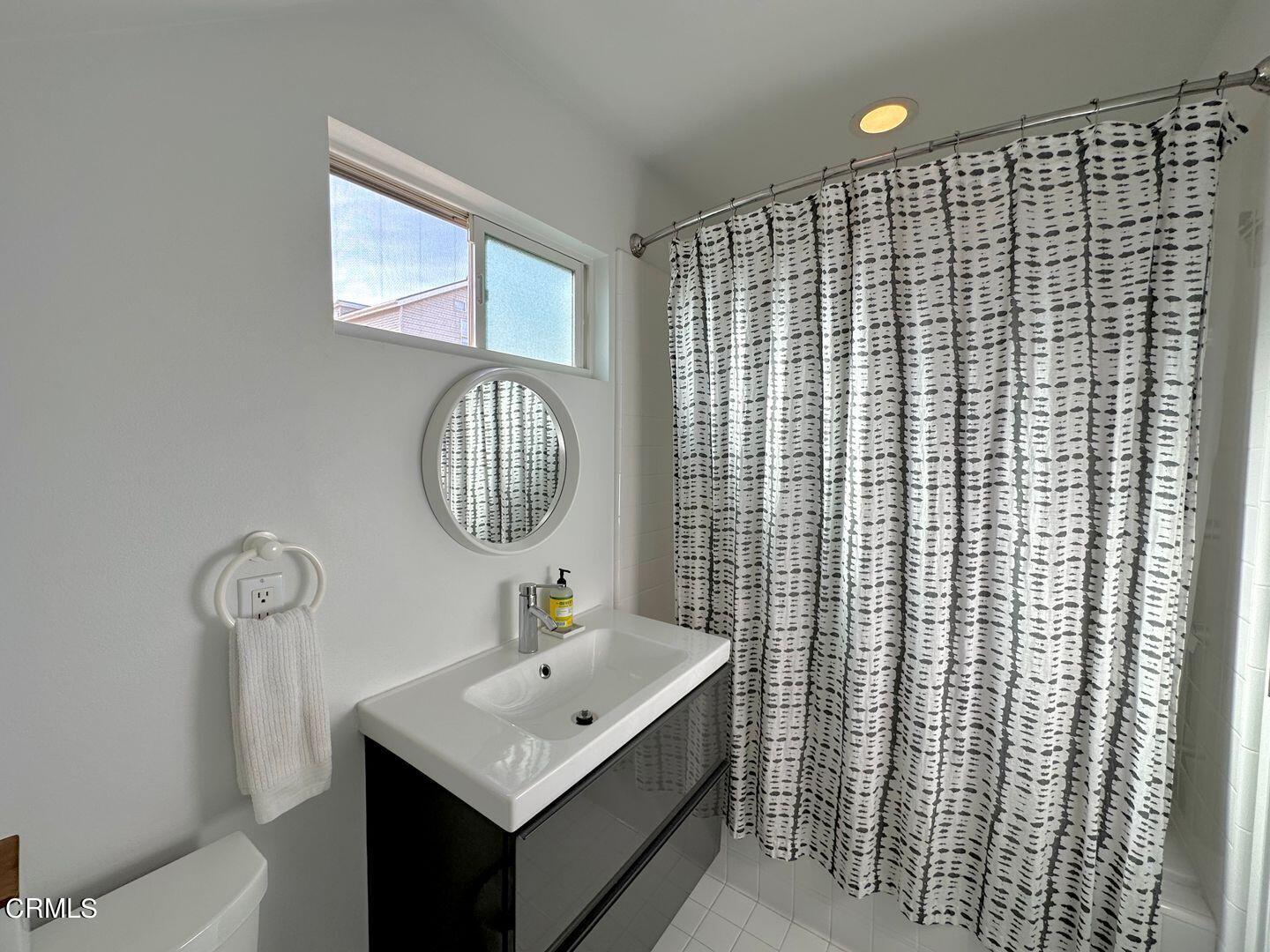 3600 Ocean Drive Oxnard, CA 93035 - Photo 23 of 36 a bathroom with a sink a toilet and shower curtain