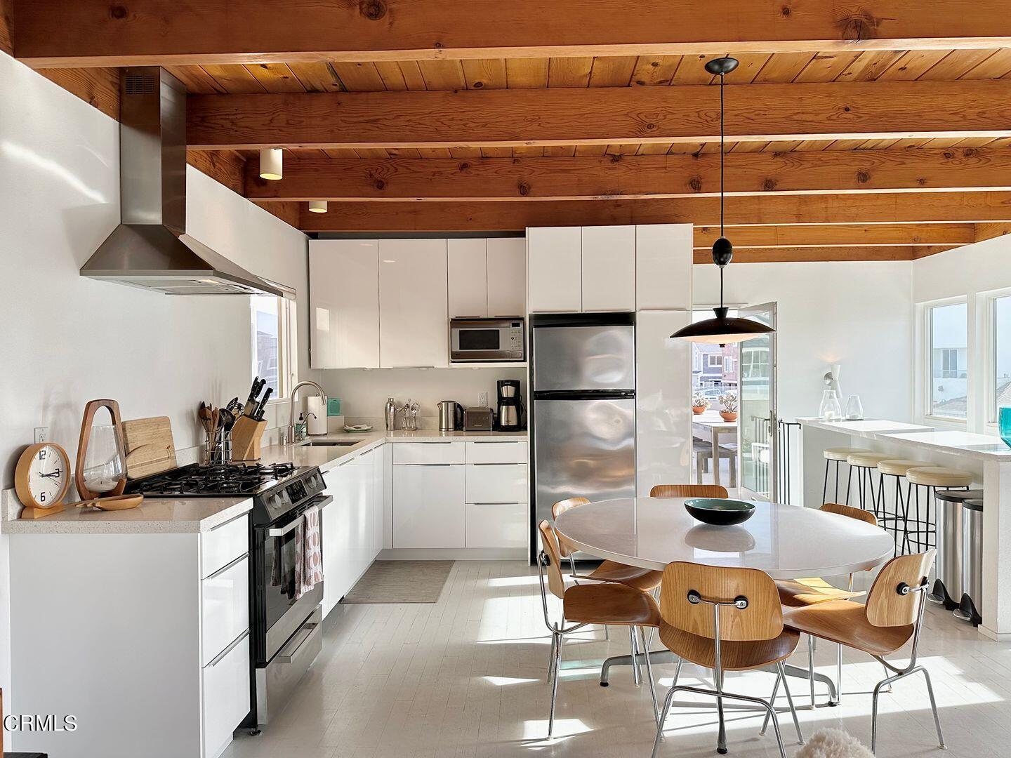 3600 Ocean Drive Oxnard, CA 93035 - Photo 10 of 36 a kitchen with a sink a stove and chairs