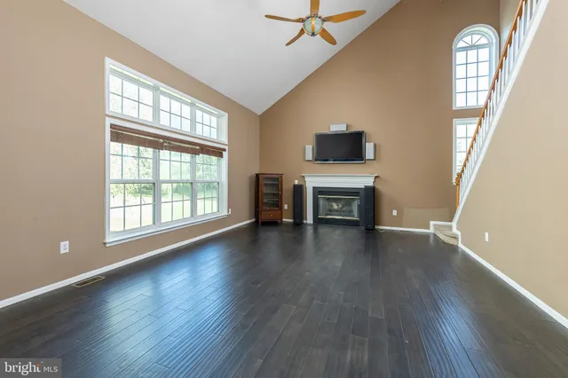 a view of a livingroom with wooden floor and furniture