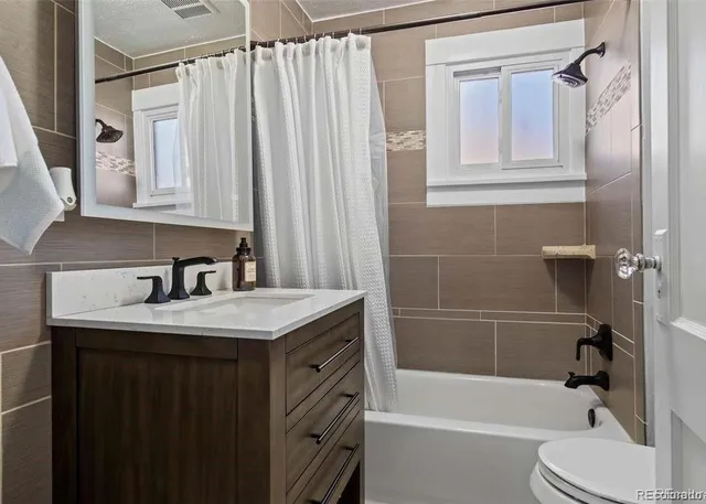 a kitchen with stainless steel appliances granite countertop a refrigerator sink and stove