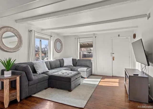 a dining room with wooden floor a chandelier a glass table and chairs