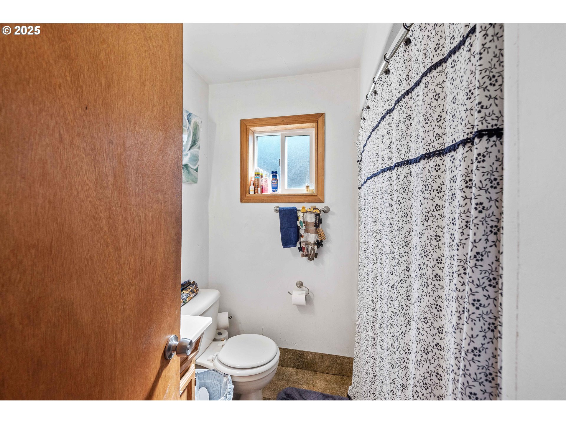 805 C Street Myrtle Point, OR 97458 - Photo 11 of 30 a bathroom with a toilet and a shower curtain