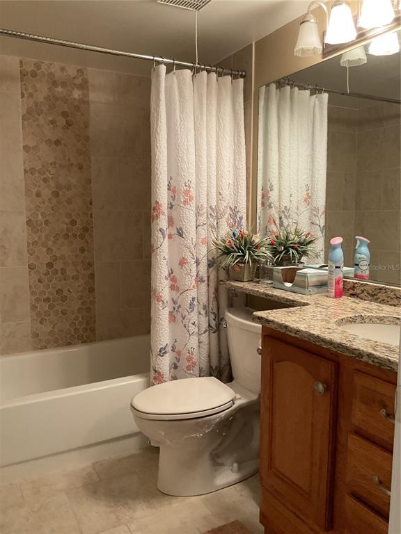 2655 Pine Ridge Way North, Unit D3 Palm Harbor, FL 34684 - Photo 21 of 31 a bathroom with a granite countertop sink toilet and shower
