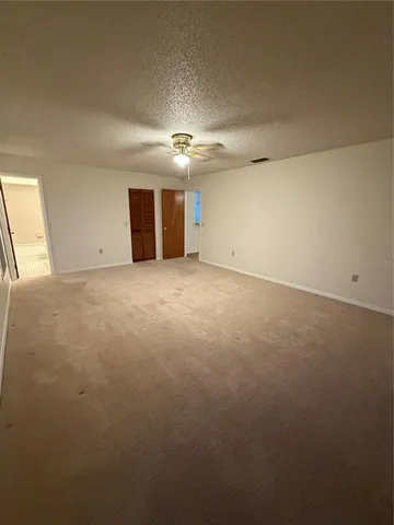 an empty room with a empty space and a ceiling fan