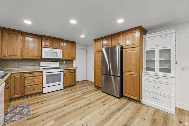 822 Pinewood Circle Price, UT 84501 - Photo 9 of 49 Kitchen featuring wood-finish flooring, recessed lighting, and a combination of wood cabinetry and a white built-in cabinet with glass doors